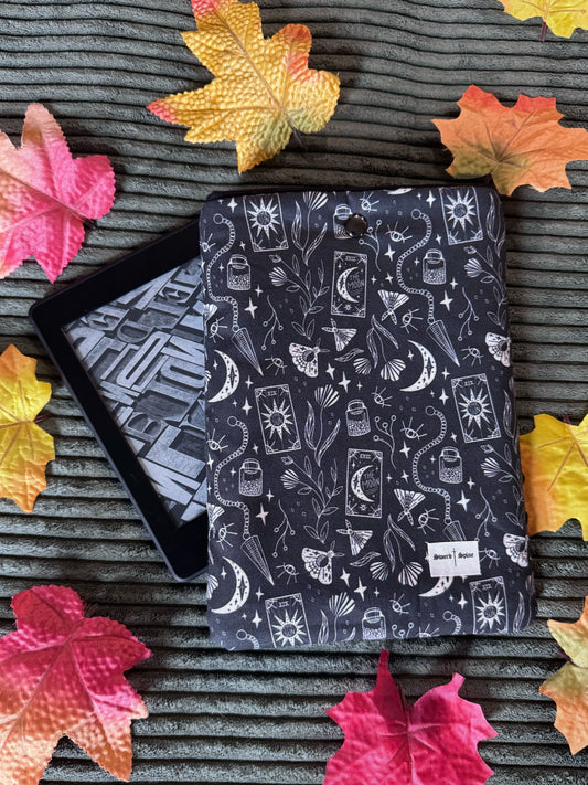 A tarot and pendulum repeated pattern marks a handmade kindle e-reader sleeve.