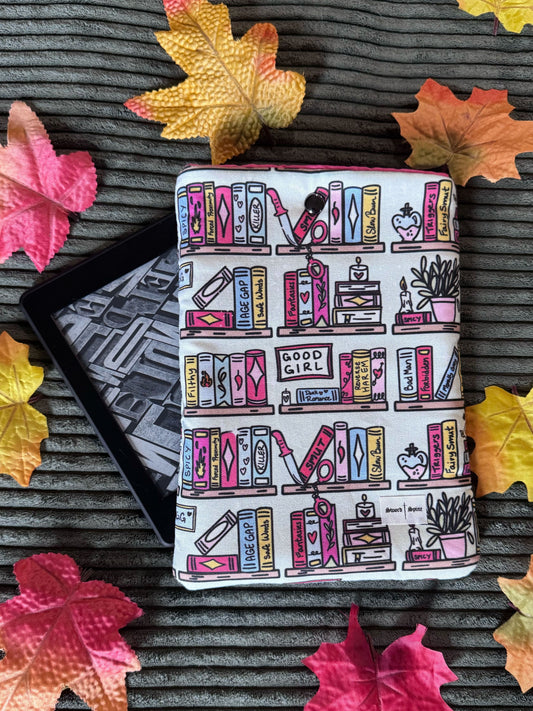 A handmade kindle e-reader sleeve featuring a repeated pattern of spicy books on a bookshelf.
