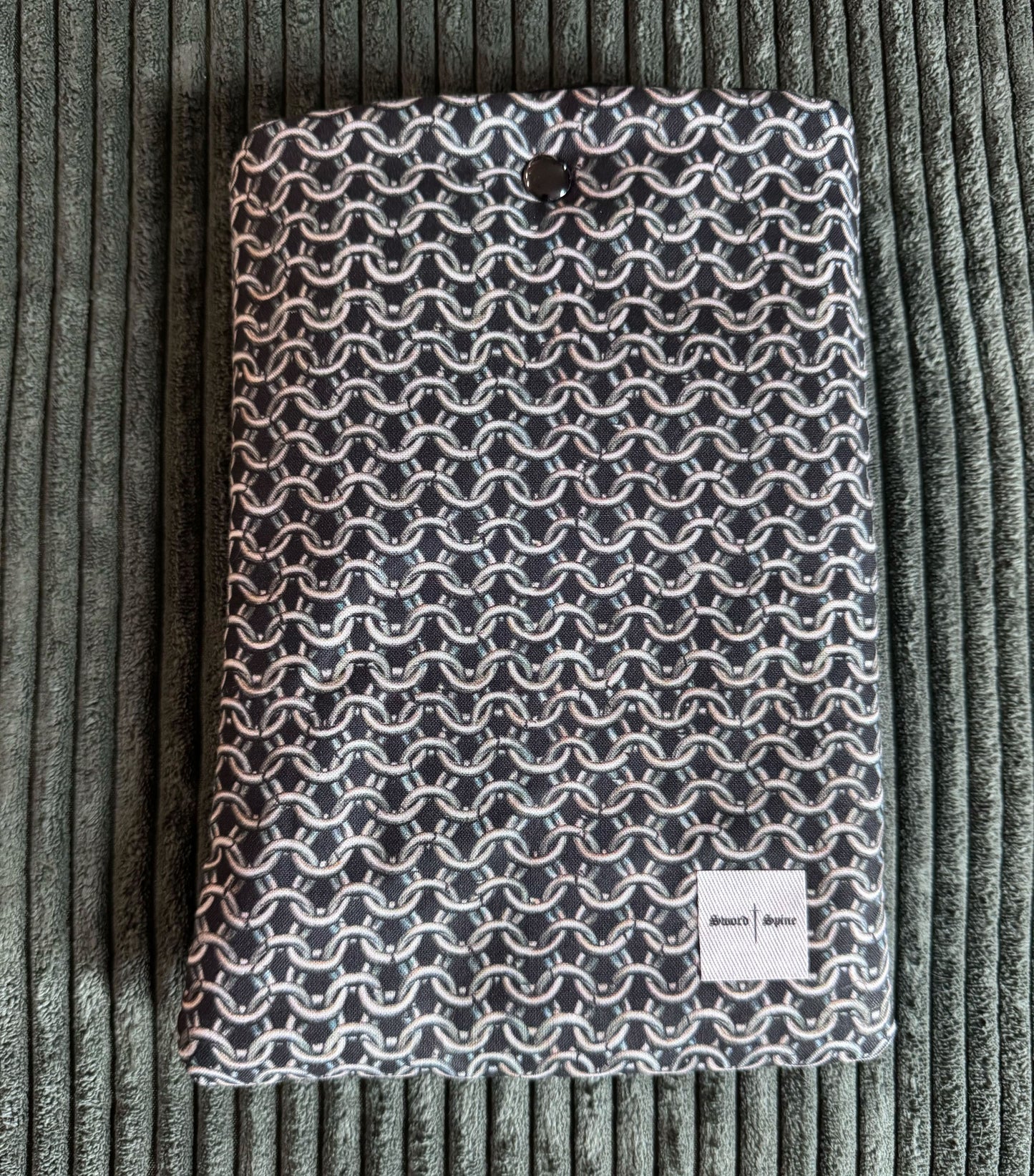 A handmade e-reader sleeve with a silver chainmail pattern.