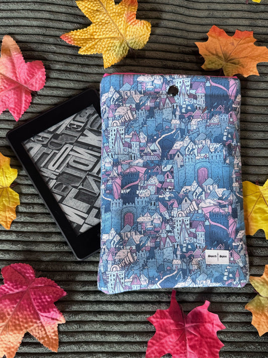 A handmade kindle e-reader sleeve featuring a repeated pattern of castles and dragons for fantasy book fans.