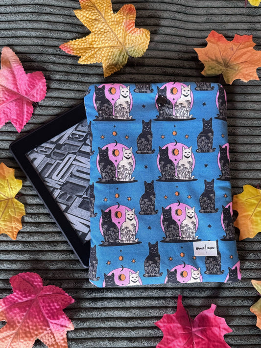 A handmade kindle e-reader sleeve featuring a repeated pattern of black and white cats and crescent moons.