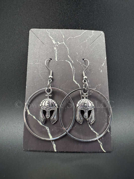A pair of silver hoops with knight's helmets in the middle displayed on a dark jewelry card.