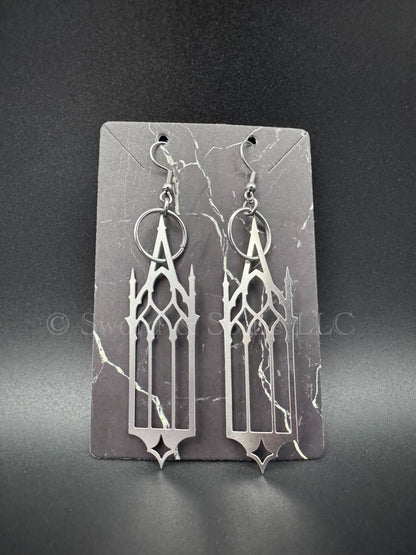 A pair of dramatic gothic cathedral window earrings displayed on a dark jewelry card.