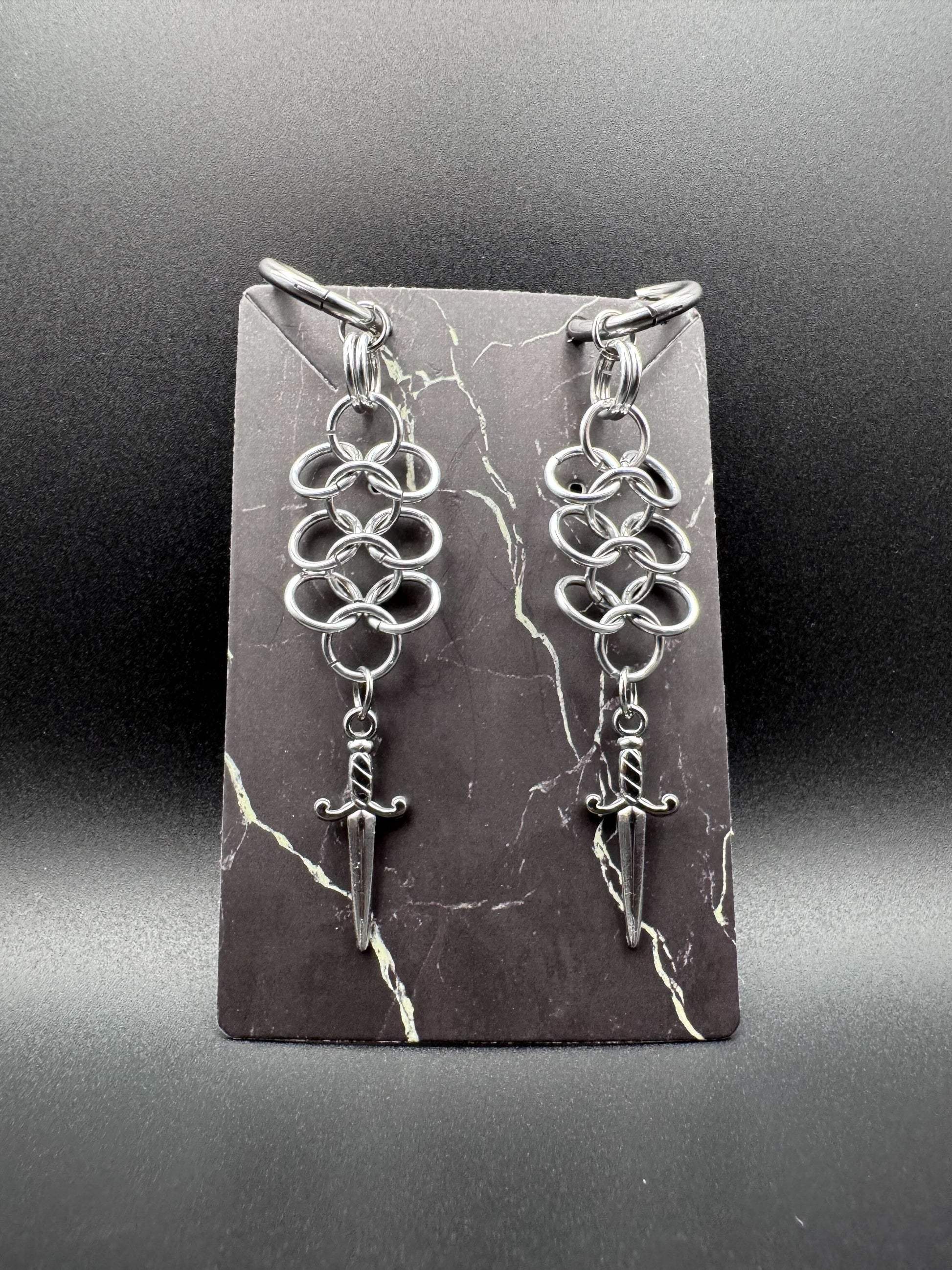 Click hoop earrings with silver chainmail and stainless steel daggers.