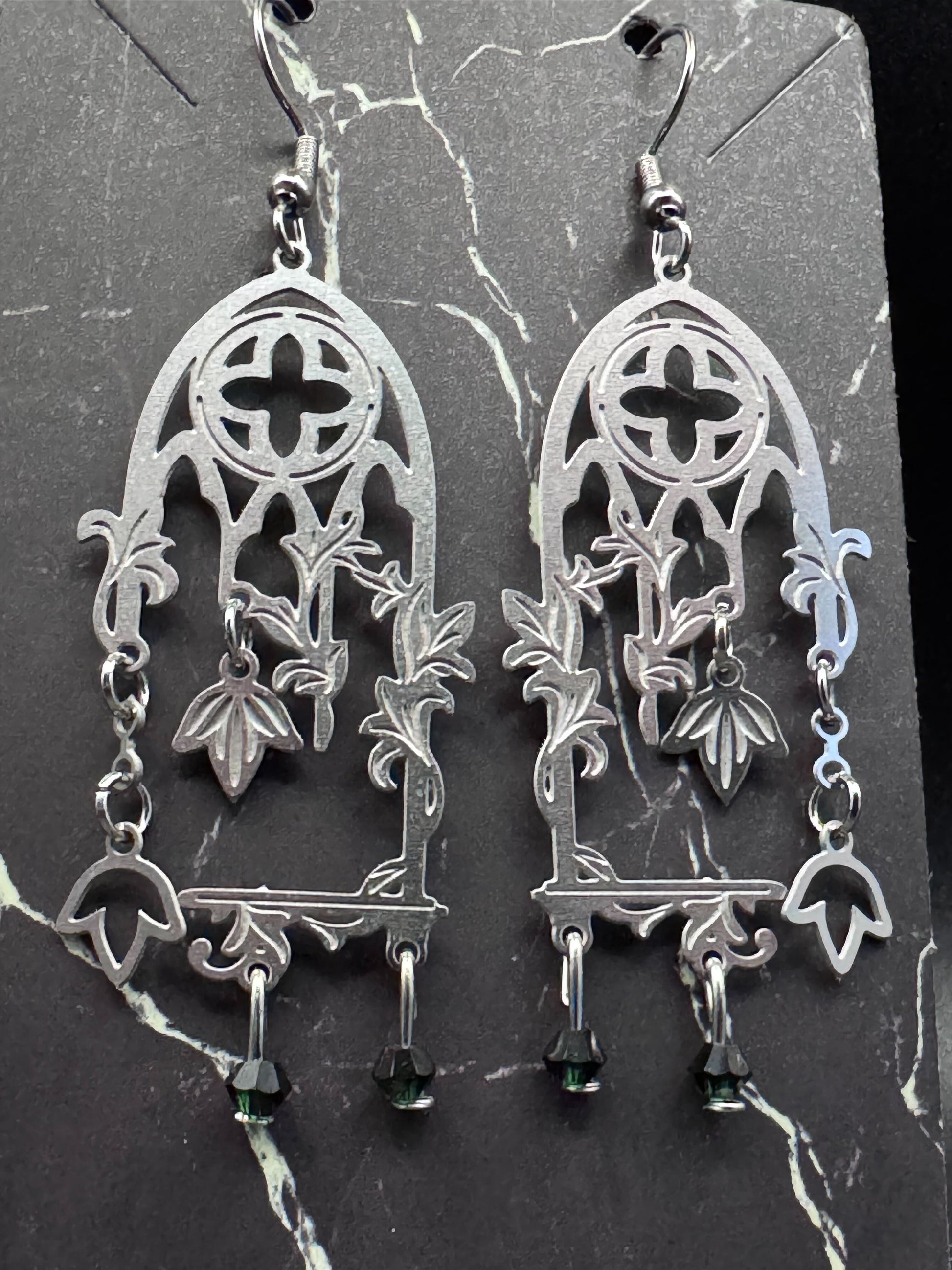 A vine winds up a pair of silver gothic cathedral windows with emerald beads.