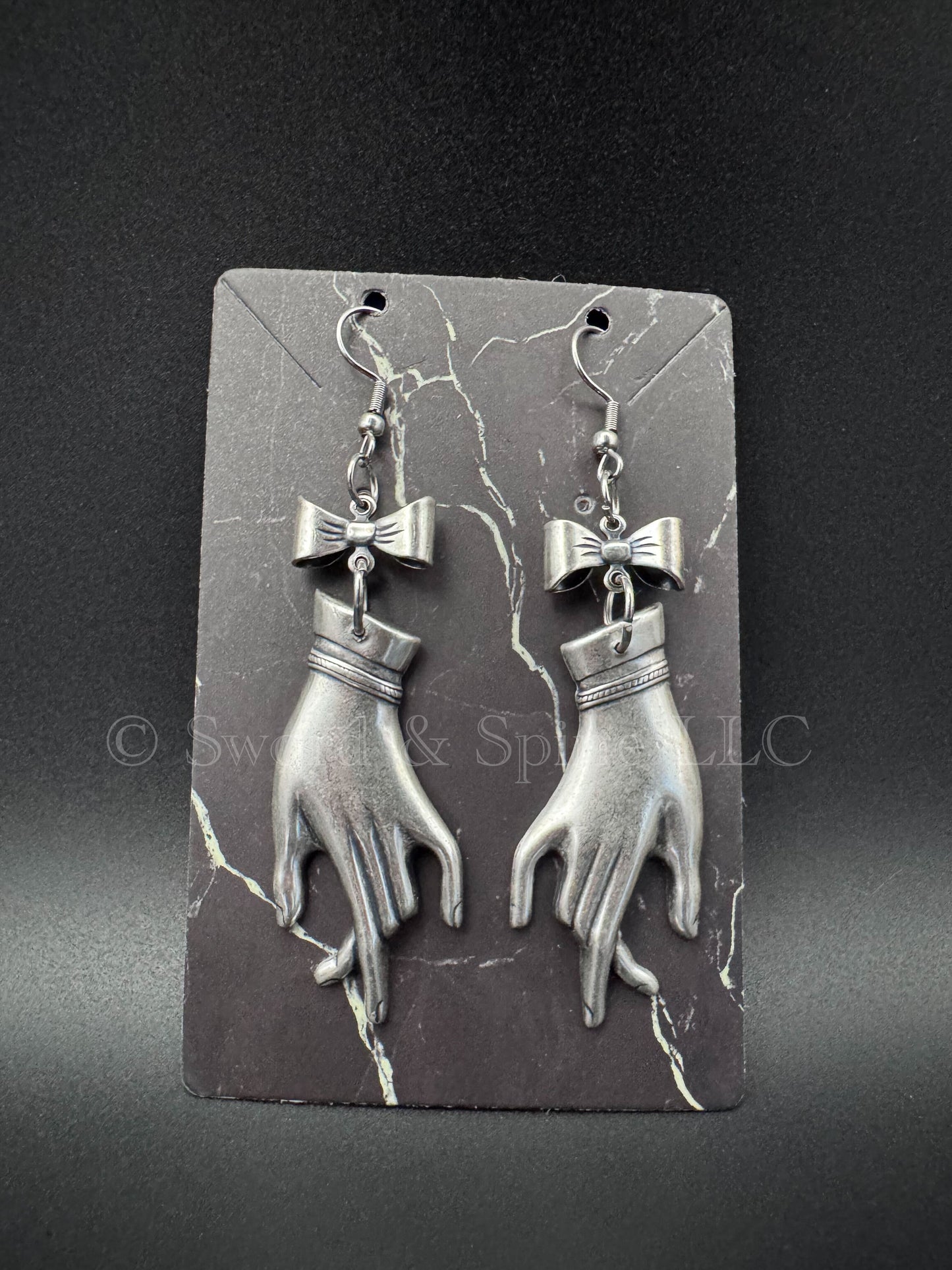 A pair of victorian mourning hand earrings with a coquette bow on each.