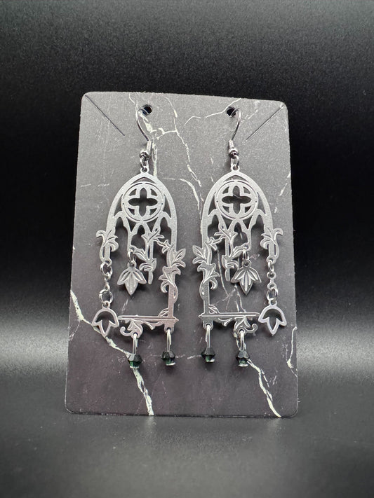 Stainless steel cathedral windows with vines and dark green emeralds.