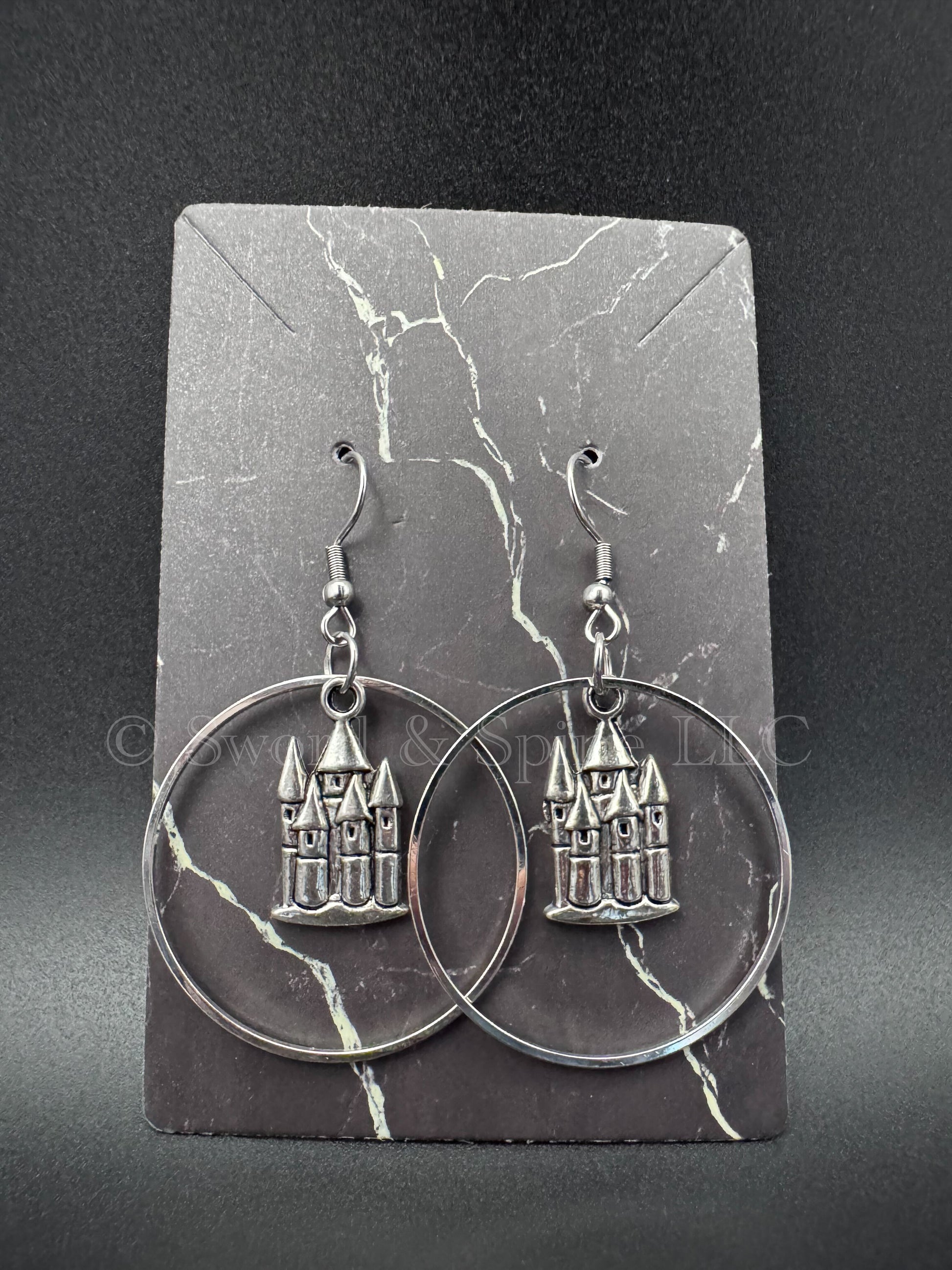 Dangled hoop earrings with an enchanted silver castle pendant in the middle.