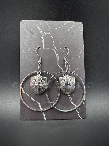 A pair of earrings featuring silver hoops with a medieval knight's shield in the middle.