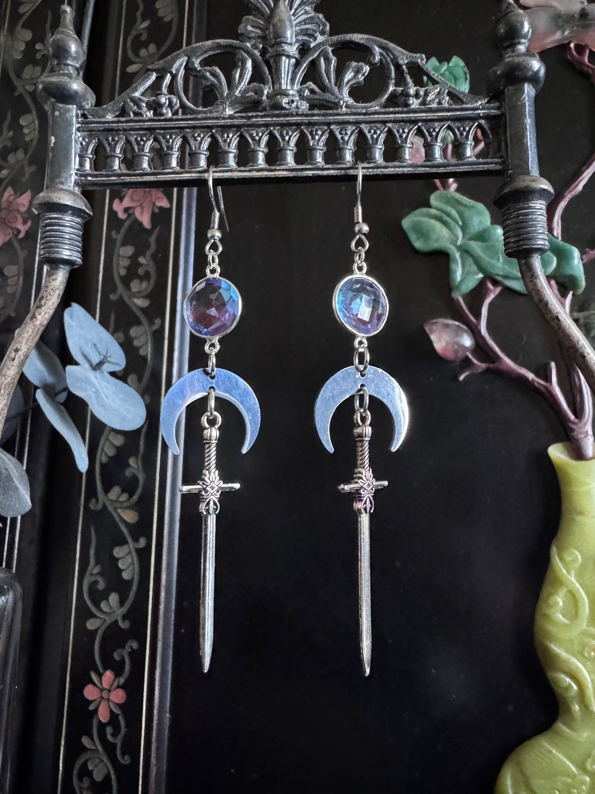 Purple and blue ombre gemstone earrings feature silver swords and crescent moons.