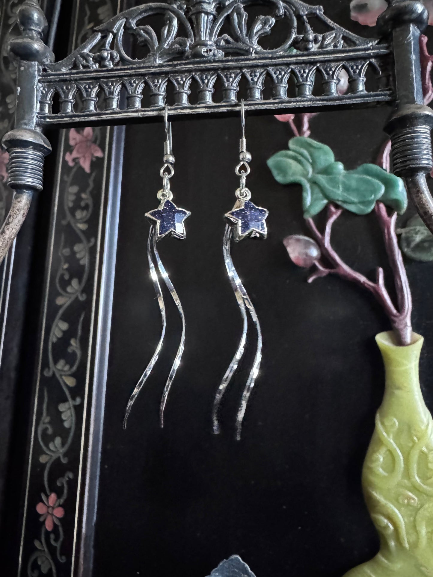 Beautiful silver earrings with sunstone shaped into stars, dangle with silver threads, creating a shooting star effect.
