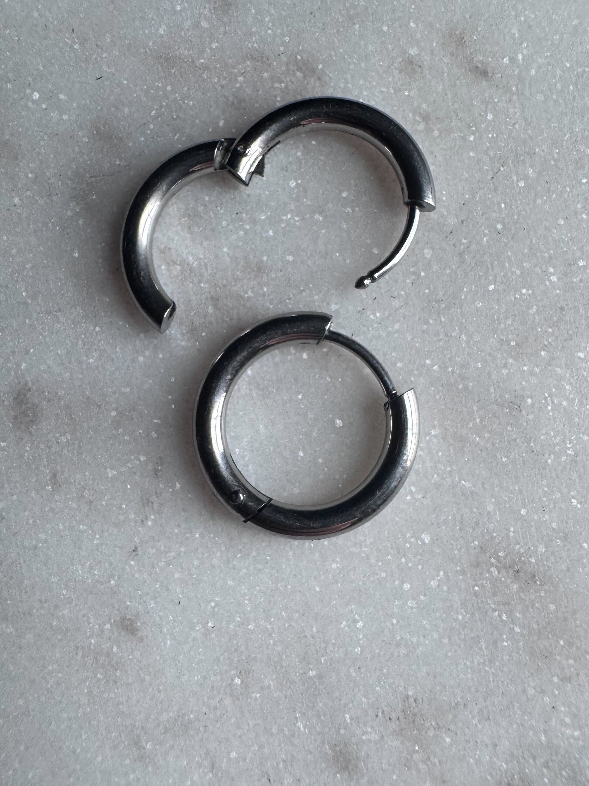Stainless steel clicker hoops on a marble background.