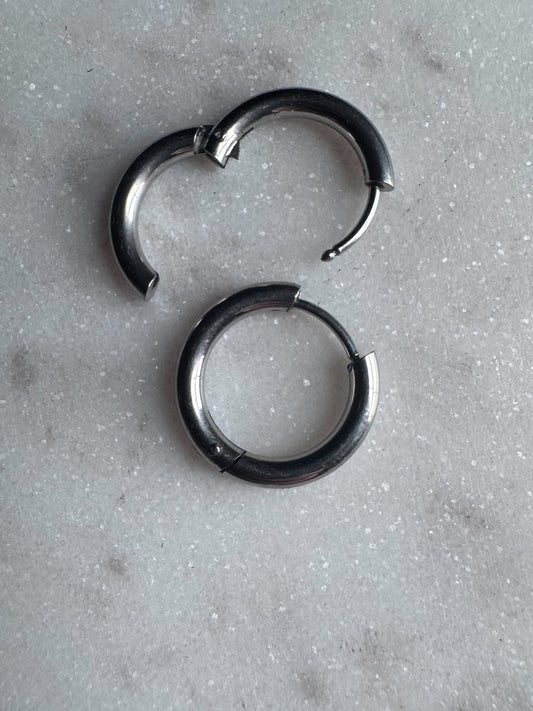 Stainless steel clicker hoops on a marble background.